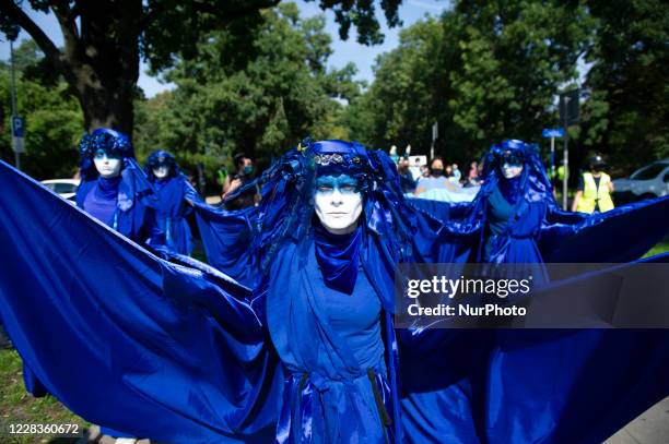 Extinction Rebellion activists dressed in blue gowns take part in the &quot;wave of sadnesses&quot; during the great march for climate change on...