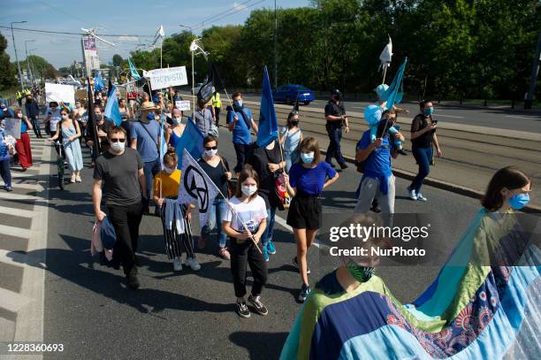 People wearing protective face masks are seen holding flags during the great march for climate on September 5, 2020 in Warsaw, Poland. A few thousand...