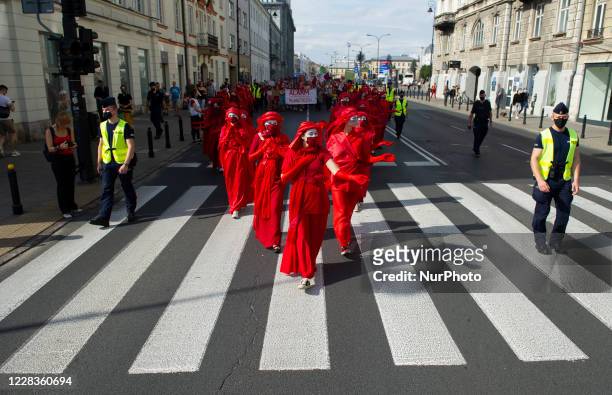 Extinction rebellion activists perform as Red Rebel Brigade during a march gainst climate change on September 5, 2020 in Warsaw, Poland. A few...