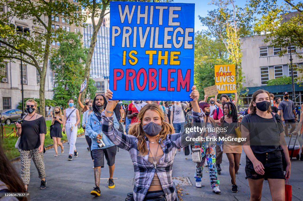 A participant holding a White Privilege Is The Problem sign...