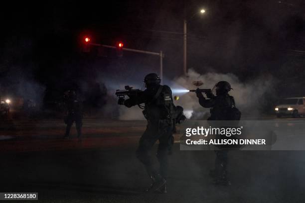 Oregon police wearing anti-riot gear fire rubber bullet hand-held weapons at protestors during the 100th day and night of protests against racism and...