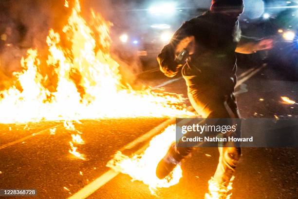 Protester, whos feet caught fire after a molotov cocktail exploded on him, runs toward a medic during a protest against police brutality and racial...