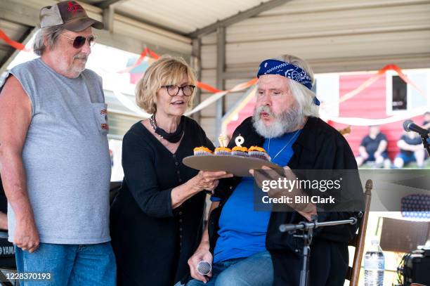 Former Rep. Ben Cooter Jones blows out candles on cupcakes with his wife Alama Viator during a performance with Cooters Garage Band during his...