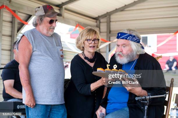 Former Rep. Ben Cooter Jones blows out candles on cupcakes with his wife Alama Viator during a performance with Cooters Garage Band during his...