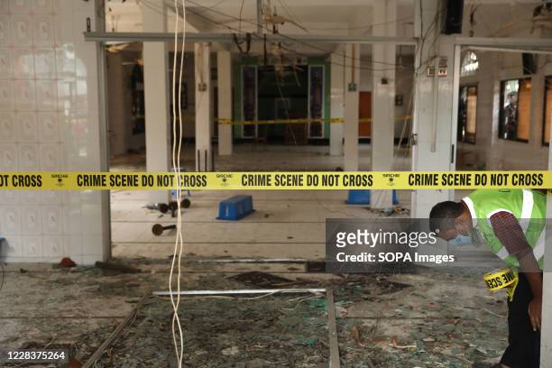 Yellow crime scene tape is seen strapped across polls inside Baitus Salat Jame Mosque in Narayanganj after several Air Conditioners exploded after...