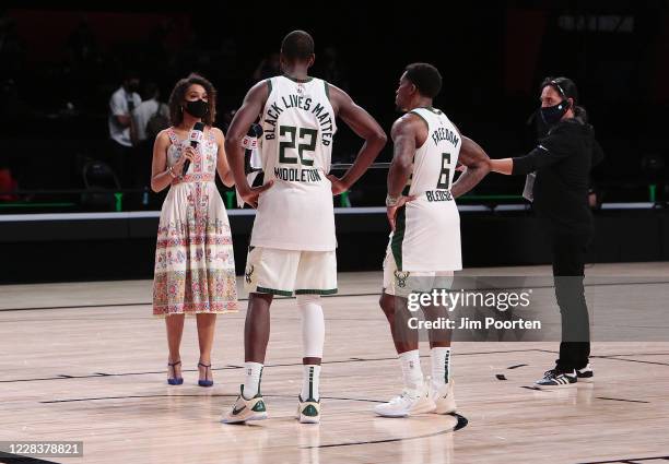 Malika Andrews of ESPN interviews Khris Middleton and Eric Bledsoe of the Milwaukee Bucks after the game against the Miami Heat during Game four of...