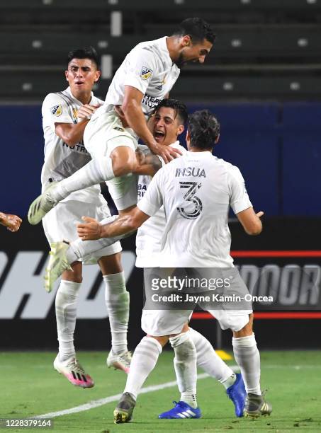 Sebastian Lletget leaps into the arms of Cristian Pavon as Joe Corona, Jonathan dos Santos and Emiliano Insua of the Los Angeles Galaxy join in to...