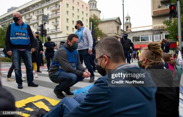 Police officer from the anti conflict team talks to protesters while they block a street during a civil disobedience action on September 7, 2020 in...