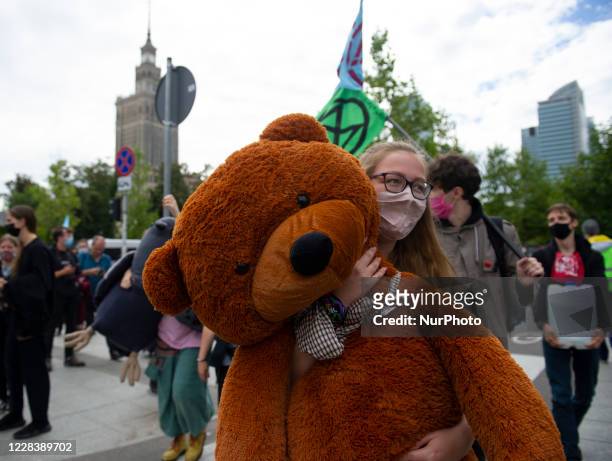 Climate activist holds a teddy bear during a civil disobedience action organised by Extinction Rebellion Poland on September 7, 2020 in Warsaw,...
