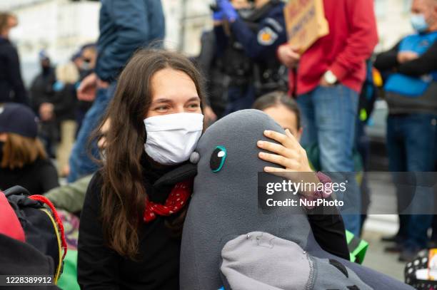 Climate activist cuddles a teddy pigeon during a civil disobedience action on September 7, 2020 in Warsaw, Poland. A few hundred protester took part...