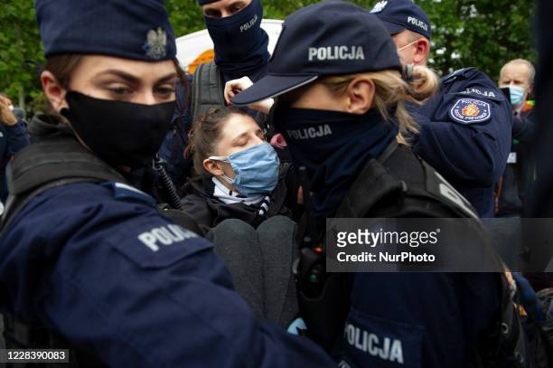 Police officers carry a climate activist during a civil disobedience action on September 7, 2020 in Warsaw, Poland. A few hundred protester took part...