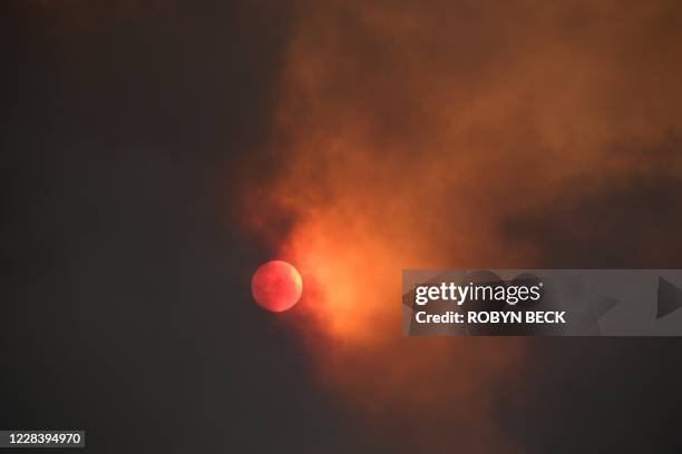 The sun is seen behind smoke from the Bobcat fire rising above in the Angeles National Forest above Duarte, California, about 27 miles northeast of...