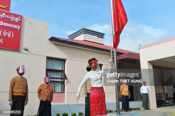 Myanmar's de-facto leader Aung San Suu Kyi and President Win Myint wear face shields and masks at a flag-raising ceremony for the National League for...