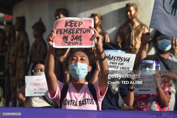 Demonstrators display placards to protest against Philippine President Rodrigo Duterte's decision to pardon US marine Lance corporal Joseph Scott...