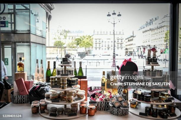 This picture taken on September 8, 2020 shows boxes of biscuits, bottles of alcohol, pastries and other high-end products displayed in a shop window...