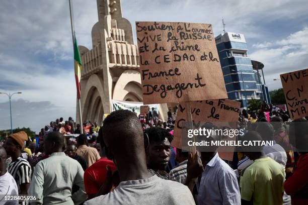 Man holds a sign reading "Support to the army, Long live Russia and China, ECOWAS and France get out" as supporters of the CNSP take part in a rally...