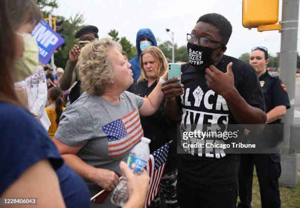 Trump supporter and Chicago activist Ja'Mal Green face off as they wait for President Donald Trump's motorcade outside Bradford High School in...