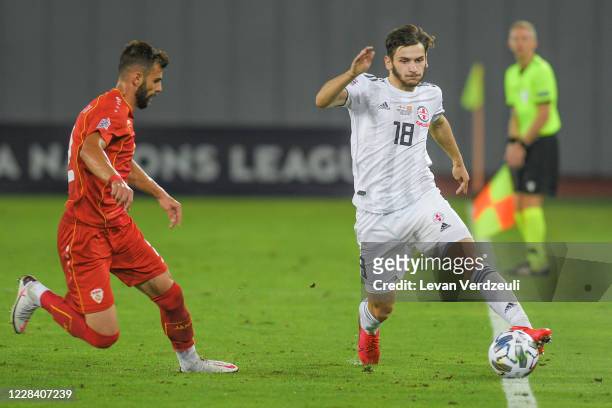 Khvicha Kvaratskhelia of Georgia dribbles with Egzon Bejtulai of North Macedonia chasing during the UEFA Nations League group stage match between...
