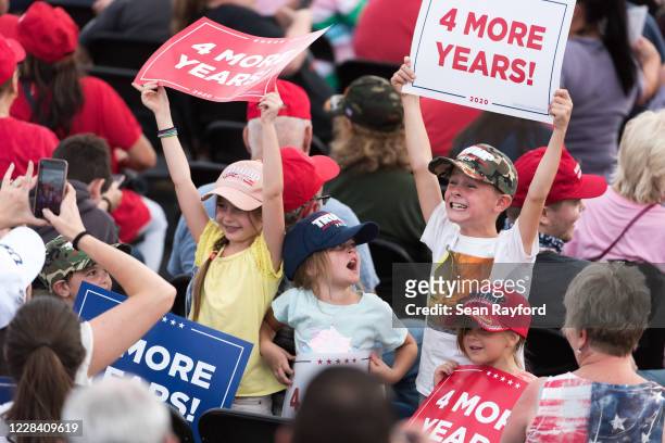 Children hold up campaign signs waiting for the arrival of President Donald Trump before a campaign rally at Smith Reynolds Airport on September 8,...