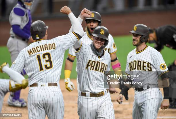 Wil Myers of the San Diego Padres, center, is congratulated by Manny Machado, Fernando Tatis Jr. #23 and Austin Nola after hitting a grand slam...