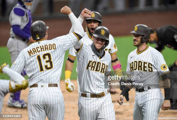 Wil Myers of the San Diego Padres, center, is congratulated by Manny Machado, Fernando Tatis Jr. #23 and Austin Nola after hitting a grand slam...