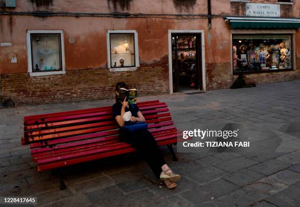 Woman reads on a bench in Venice on the seventh day of the 77th Venice Film Festival, on September 8 during the COVID-19 infection, caused by the...