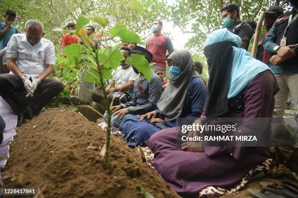 Group of Rohingya migrants gather to bury a 21-year-old woman in Lhokseumawe, Aceh on September 9 after landing with some 300 other migrants on...