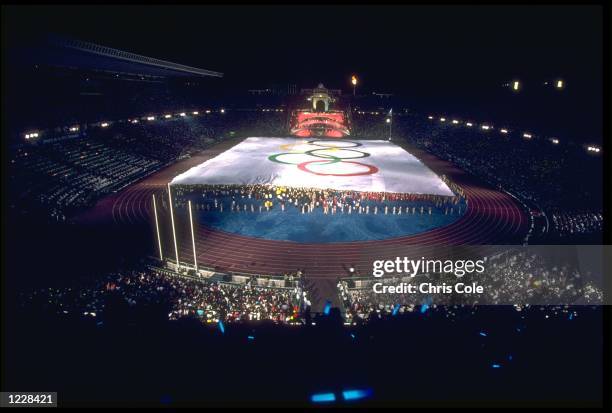 A GIANT OLYMPIC FLAG IS PULLED ACROSS THE FIELD INSIDE THE OLYMPIC STADIUM DURING THE OPENING CEREMONY OF THE 1992 BARCELONA OLYMPICS.