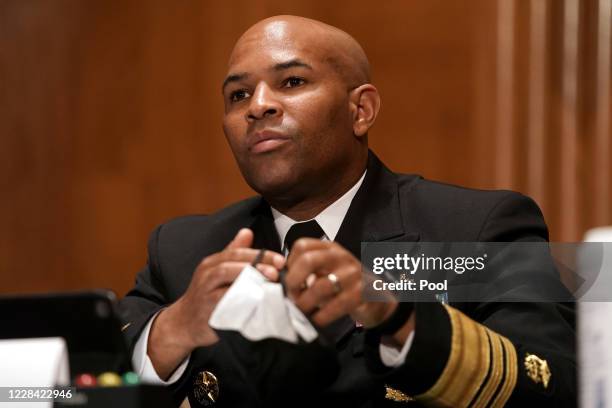 Surgeon General Jerome Adams takes his mask off to give his opening statement during a Senate Health, Education, Labor, and Pensions Committee...