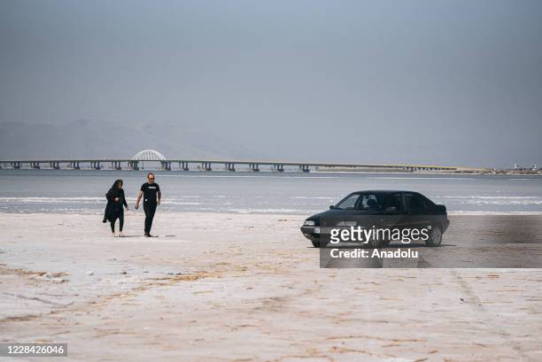 People walk at the Lake of Urmia in the northwest of Iran, which had been shrinking in one of the worst ecological disasters of the past 25 years,...