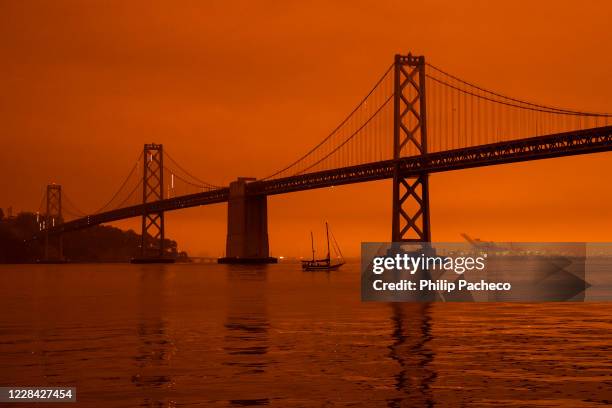 Ship passes beneath the Bay Bridge as smoke from various wildfires burning across Northern California mixes with the marine layer, blanketing San...