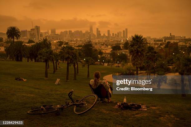 Person sits in Delores Park as smoke and fog hang over the skyline in San Francisco, California, U.S., on Wednesday, Sept. 9, 2020. Powerful, dry...