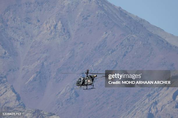 An Indian helicopter flies over a mountain range in Leh, the joint capital of the union territory of Ladakh bordering China, on September 10, 2020.