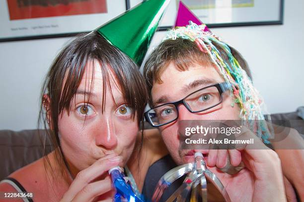 couple blowing party horn blower - party horn blower imagens e fotografias de stock