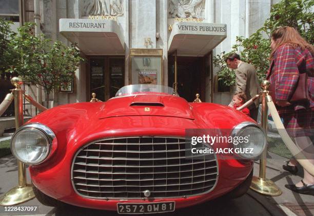 Des personnes regardent une Ferarri 225 S Barchetta Touring de 1952, qui est estimée entre 3 et 5 millions de francs, le 23 mai à Drout-Montaigne à...