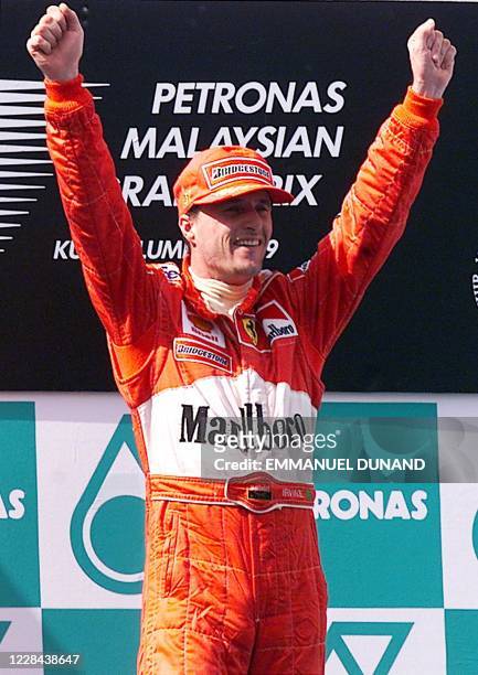 Ferrari team Formula One driver Eddie Irvine of Northern Ireland celebrates 17 October 1999 on the podium of the Malaysian Grand Prix in Sepang....