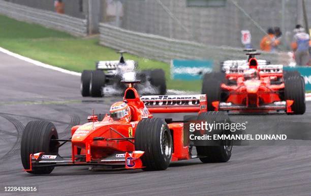 Ferrari Formula One driver Eddie Irvine of Northern Ireland leads ahead of teammate Michael Schumacher and the two McLaren cars of David Coulthard...