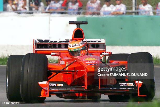 Ferrari team Formula One driver Eddie Irvine of Northern Ireland powers his way down the Sepang circuit 16 October 1999 during the second timed...