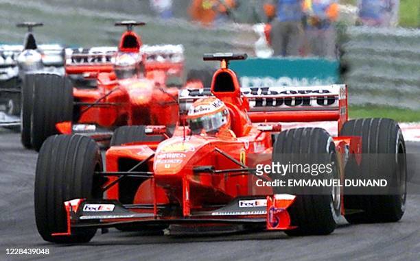 Ferrari Formula One driver Eddie Irvine of Northern Ireland leads ahead of teammate Michael Schumacher 17 October 1999 during the Malaysian Grand...