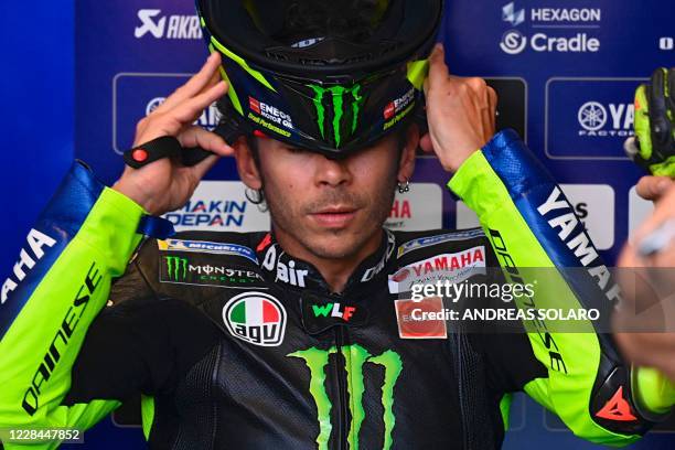 Monster Energy Yamaha's Italian rider Valentino Rossi wears his helmet before the start of the first free practice session ahead of the San Marino...