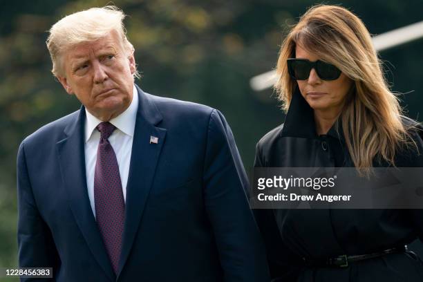 President Donald Trump and first lady Melania Trump walk to the White House residence as they exit Marine One on the South Lawn of the White House on...