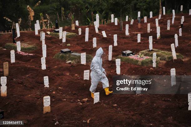 Municipal cemetery worker walks through a special cemetery for suspected Covid-19 victims on September 11, 2020 in Jakarta, Indonesia. Jakartas...