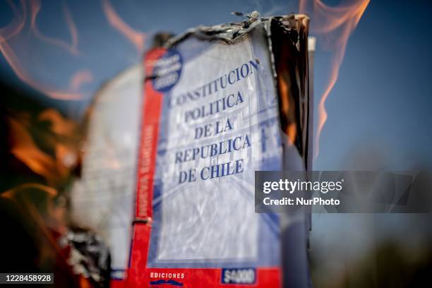 Detail as demonstrators burn a Chilean constitution during a protest on the 47th anniversary of the last military coup that ousted President Salvador...