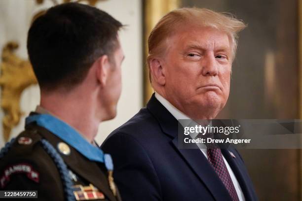 President Donald Trump looks on after presenting the Medal of Honor to Sergeant Major Thomas P. Payne, United States Army, for conspicuous gallantry...