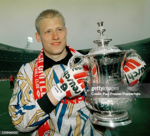 Manchester United goalkeeper Peter Schmeichel celebrates with the trophy after the FA Cup Final between Chelsea and Manchester United at Wembley...