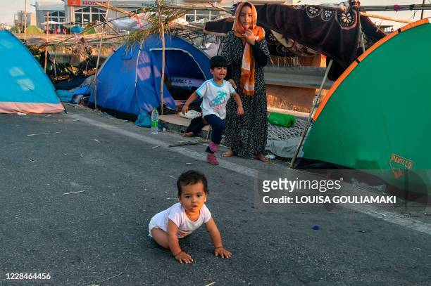 Baby crawls on a road leading to Mytilene town on the Greek island of Lesbos on September 12 a few days after a fire destroyed the Moria refugee...