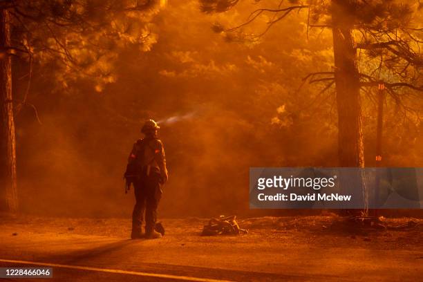 Firefighter keeps watch on flames that could jump the Angeles Crest Highway at the Bobcat Fire in the Angeles National Forest on September 11, 2020...