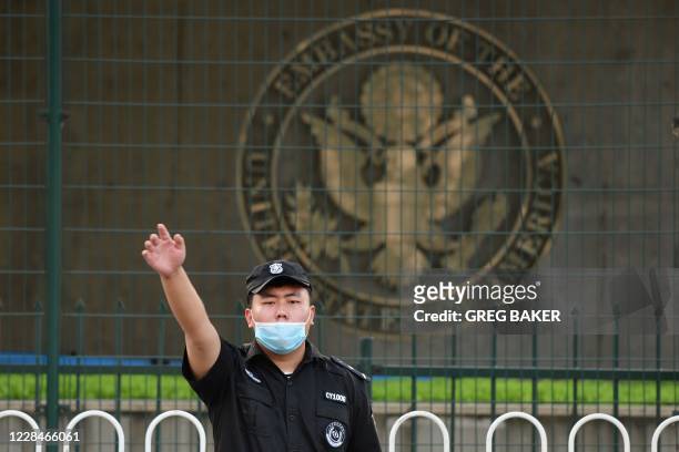 Chinese security guard gestures outside the US embassy in Beijing on September 12, 2020. - Beijing will impose "reciprocal restrictions" on all...