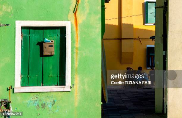 People sit together in a street of Burano, the most colorful island in the Venice lagoon, on September 11, 2020.