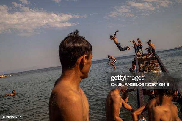 Migrants and refugees enjoy the sea near Mytilene, on the Greek island of Lesbos on September 12 a few days after a fire destroyed the Moria refugee...